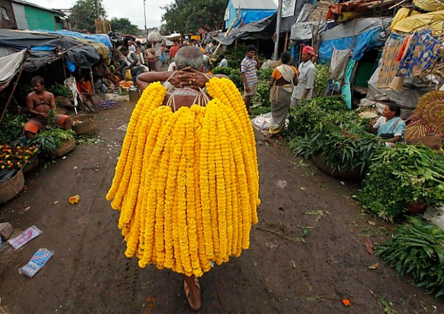 A vendor sells garlands of marigold flowers at a wholesale flower market ahead of "Janamashtmi", in Kolkata