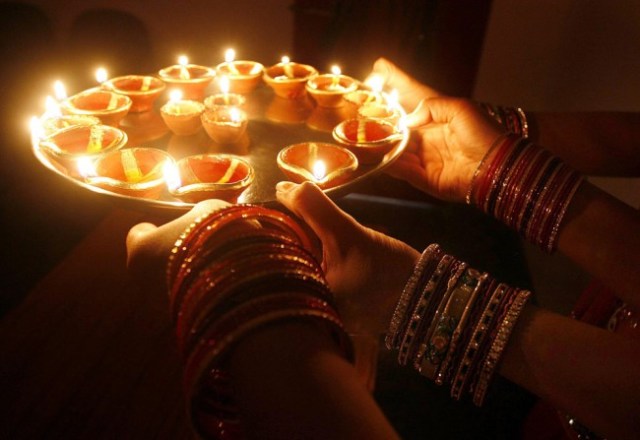 Indian-girls-hold-earthen-lamps-on-the-occasion-of-Dhanteras-ahead-of-the-Diwali-festival-in-Bhopal-India-late-night-on-Nov.-11.-The-word-Dhan-means-wealth-and-the-day-before-the-Diwali-festival-has-a-grea
