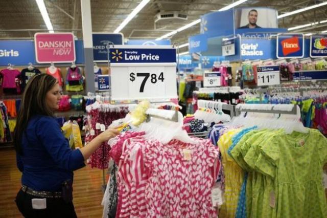 An employee cleans a clothes rack at the Walmart Supercenter in Bentonville, Arkansas June 5, 2014. The Walmart Stores Inc. annual shareholder meeting takes place June 6, 2014. REUTERS/Rick Wilking